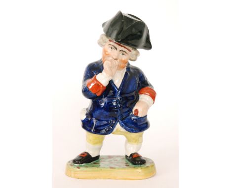 A 19th Century Staffordshire figural model of a 'snuff taker', he stood in a blue overcoat and yellow breaches on a painted b