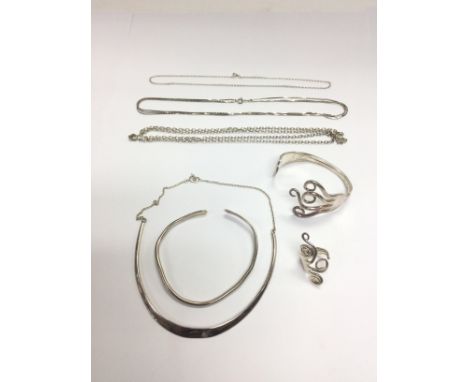 A collection of silver jewellery comprising a silver torque and chain, bangle, ring and chains. Shipping category A.