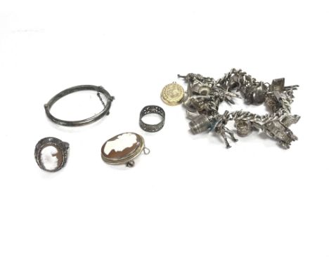 A collection of silver items including a silver charm bracelet cameo ring and broach etc Postage B
