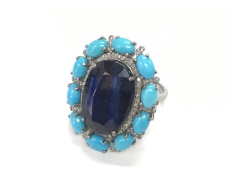 Large oval cluster ring in white metal set with large oval kyanite surrounded by turquoise and round diamonds, boxed. Kyanite