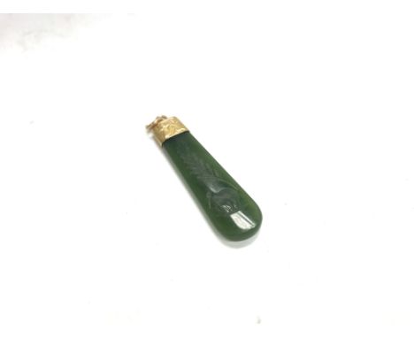 A gold unmarked jade pendant.
