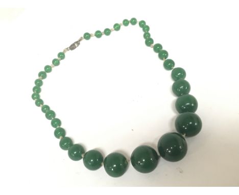 A green jade coloured bead necklace of graduating size.
