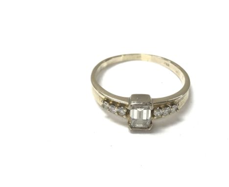 A 14ct gold ring set with a baguette diamond and smaller diamonds on the side. Central stone approx 0.30ct 2.8g and size Q.