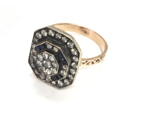 Unhallmarked Art Deco style rose gold silver topped ring with chamfered corners, set with RBC diamonds and calibre cut sapphi