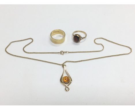 A gold and amber pendant, an 18ct gold wedding band and a 9ct gold ring set with a red stone, total weight approx 13.4g. Ship