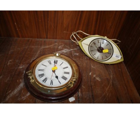 A RETRO EYE SHAPED METAMEC ELECTRIC ALARM CLOCK TOGETHER WITH A CIRCULAR WALL CLOCK