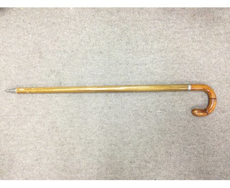 A walking stick fitted with a long glass phial. Shipping category D.