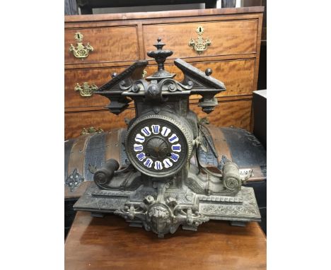 A French late 19th century mantel clock with shaped top and scrolls raised mask the movement striking on a bell with pendulum