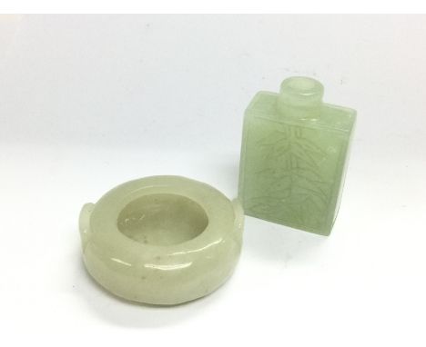 Two small jade items comprising a scent bottle and a circular vessel, bottle approx 5cm. Shipping category A.