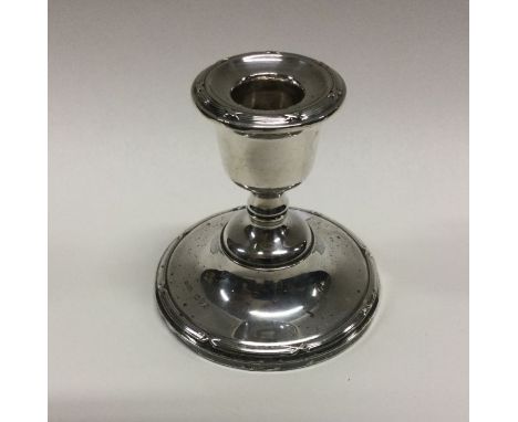 A heavy silver candlestick with embossed border. Birmingham. Approx. 210 grams. Est. £20 - £30.