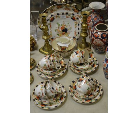 A John Maddock and Sons Geisha pattern serving dish, an associated part tea service; a pair of Georgian brass candlesticks
