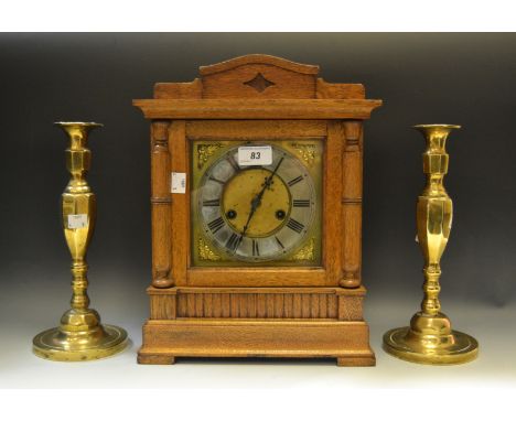 A Victorian oak mantel clock, twin winding holes, Roman numerals; a pair of Georgian brass candlesticks (3)