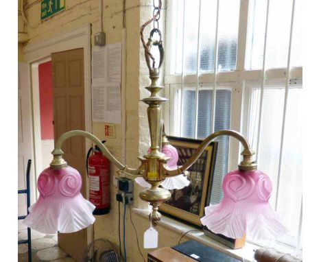 Brass hanging electric ceiling light of three scrolled branches with cranberry frosted glass shades, width 40cm. Condition re