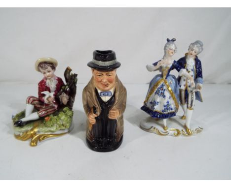 A Royal Doulton Toby jug depicting Winston Churchill and two further European ceramic figurines to include Capodimonte and on