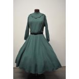 A 1950s green day dress, having black scalloped detail to bodice, high collar, long sleeves, full