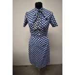 A 1950s blue blouse and skirt, with white dot pattern, having bow to neck of blouse and button