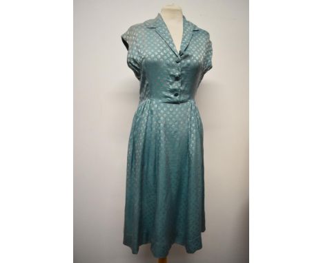 A late 1940s/early 50s day dress of sea foam green medium weight silk, having gathers to the fabric at the hips, faux button 