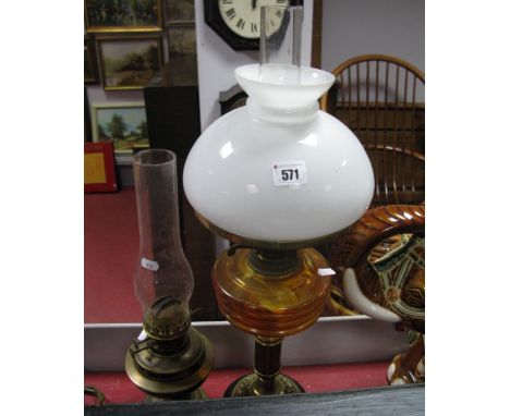 An Early XX Century Brass Oil Lamp, on circular wooden base with clear (overpainted) glass well and later shade; another. (2)