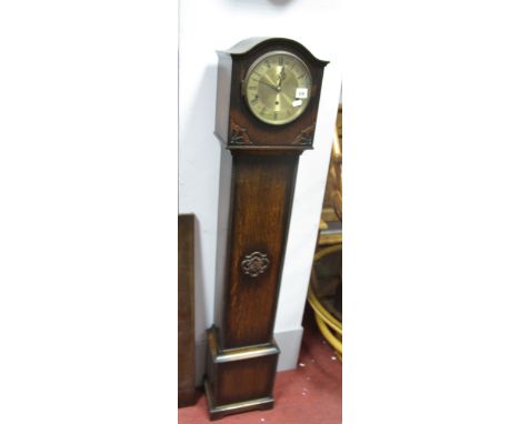 A 1920's Oak Grandmother Clock, with an arched hood, silvered dial, trunk with applied decoration, on bracket feet.