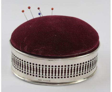 A 1920s silver cased trinket box with pin cushion lid
Of oval outline, the openwork mount to the fabric covered oval shape ca