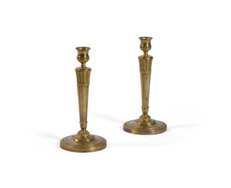 A PAIR OF EMPIRE ORMOLU CANDLESTICKS FRENCH, EARLY 19TH CENTURYEach with arrow feather banding above facetted columns, stiff 