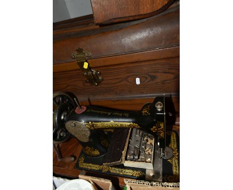 A METAL TRUNK AND A SEWING MACHINE, comprising a vintage tin trunk with wood effect finish, height 41cm x width 64cm x depth 