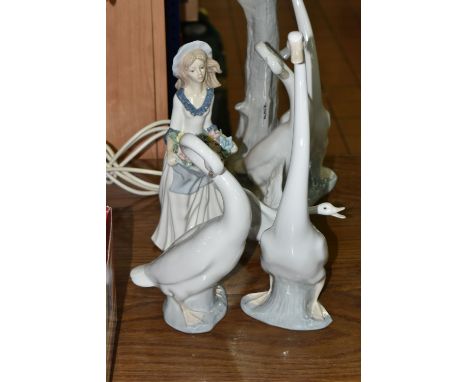 A LARGE NAO TABLE LAMP AND FOUR FIGURINES, comprising a figural table lamp, height 47cm (reglued metal fitting), a pair of Na