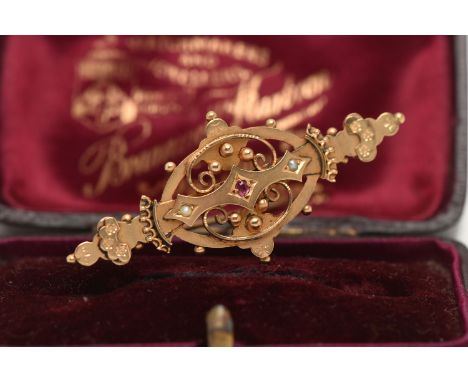 A BOXED 9CT GOLD BROOCH, open work brooch set with a small circular cut ruby and two small split pearls, fitted with a brooch