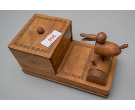 A 20th century cigarette smokers mechanical dispenser having a light mahogany outer case with inlayed decoration and a duck f