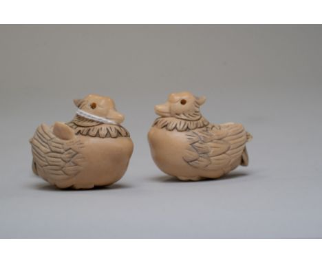 A pair of ornately carved Japanese netsuke of a male and female duck carved in animal horn and bearing character seal mark to