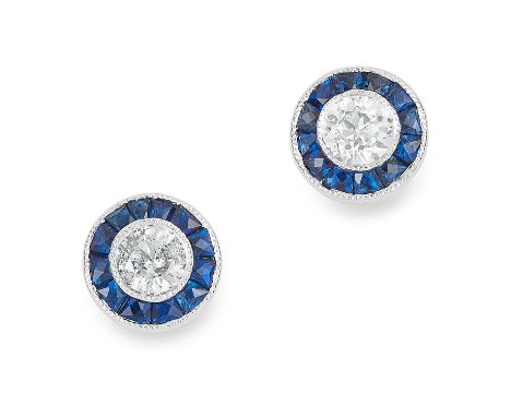 SAPPHIRE AND DIAMOND EARRINGS in 18ct white gold, each set with a round cut diamond in a border of step cut sapphires, stampe