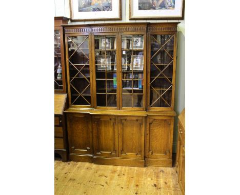 Oak breakfront bookcase having four glazed panel doors above four panelled cupboard doors, 152cm by 192cm