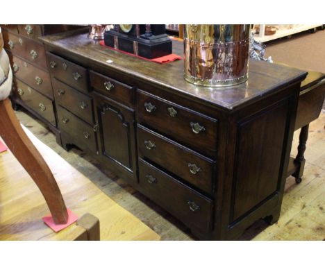 Period oak dresser having central drawer above arched fielded panel door flanked by two banks of three drawers, 167cm by 88cm