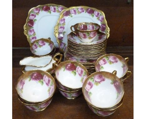 Royal Albert Rose pattern tea ware comprising eleven cups, ten saucers, twelve side plates, two sandwich plates, cream and su