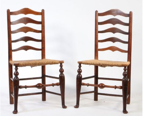 A Pair of George III ladder-back dining chairs, the shaped splats above rush seats, on shell carved turned legs , turned stre