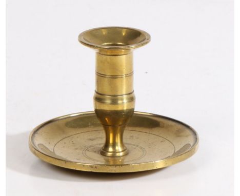 A George III cast brass lantern candlestick, circa 1800The straight-sided socket with a flared flange, on an urn-shaped stem,