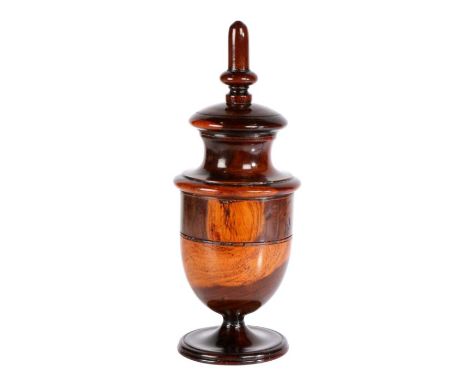 A George III lignum vitae coffee grinder, circa 1790

Having a tall finial above an urn-shaped body enclosing a grinder, 30cm