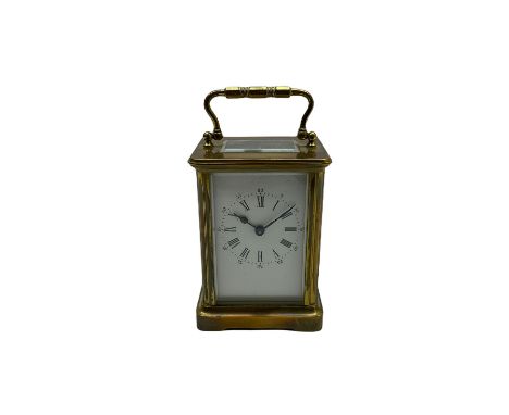 A late 19th century French timepiece carriage clock in a corniche case with a white enamel dial and Roman numerals, minute ma