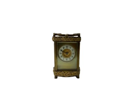 An early 20th century French timepiece carriage clock in a Louis XV Doucine case raised on four turned bun feet with overlaid