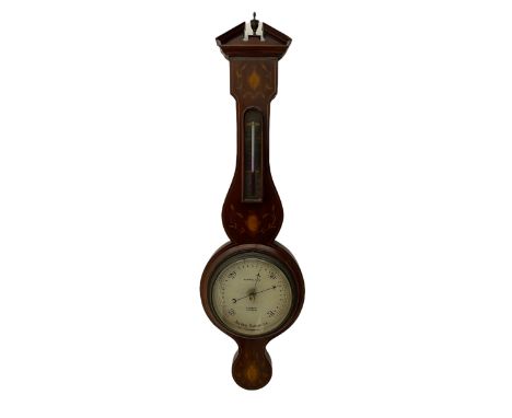 A compact Edwardian Aneroid barometer in a Regency "Sheraton style" case, broken pediment with finial and rounded base, mahog