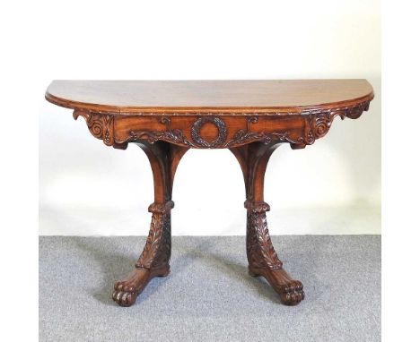 An unusual 19th century mahogany console table, of D shape, the frieze carved with scrolls and a wreath, on scrolled legs, te
