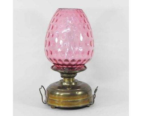 A 19th century brass oil lamp, with a dimpled cranberry glass shade