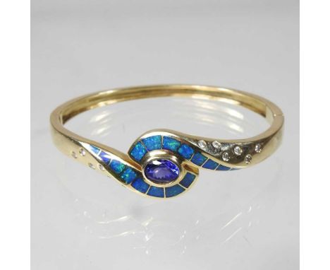 A 14 carat gold, diamond, opal and tanzanite bangle, of hinged design, set with a central tanzanite, within an opal wave, fla