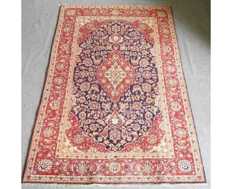A Persian Sarouk rug, with a central medallion, on a blue field, 258 x 160cmOverall condition looks to be complete, with no s