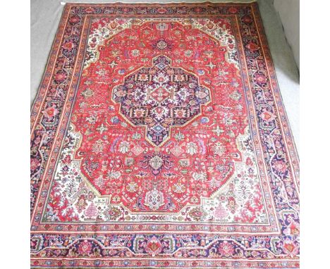 A large Persian Tabriz carpet, with a large central medallion, within a segmented flowerhead, 398 x 300cm