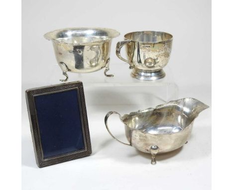 An early 20th century silver cup, Sheffield 1932, 151g, 6cm high, together with an early 20th century silver cream jug and ma