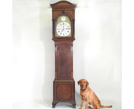 A good late 19th century oak cased longcase clock, of large proportions, the arched fourteen inch brass dial with silvered ch