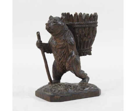 A 19th century Black Forest carved wooden model of a hiking bear, carrying a basket on his back and holding a stick, 13cm hig