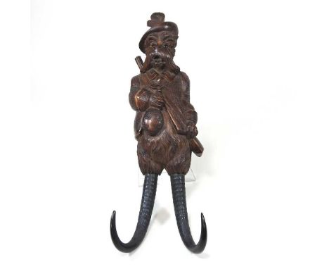 A 19th century Black Forest carved wooden whip hook, in the form of a terrier, with two antler hooks below, 36cm highWas musi