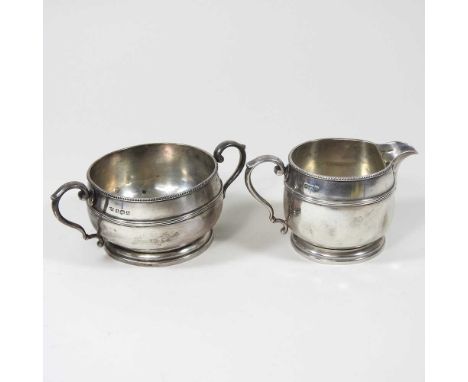An early 20th century silver cream jug, 138g, 7cm high, together with a matching sucrier, by Mappin &amp; Webb, Birmingham 19